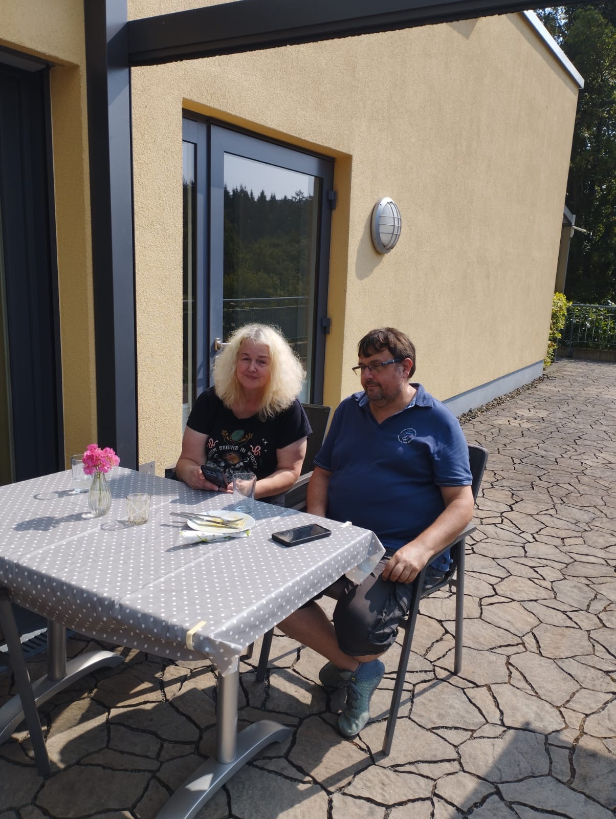 Frau und Mann sitzen am gedeckten Tisch auf der Hospizterrasse Grillnachmittag 2025 Frau und Mann sitzen am gedeckten Tisch auf der Hospizterrasse Grillnachmittag 2025