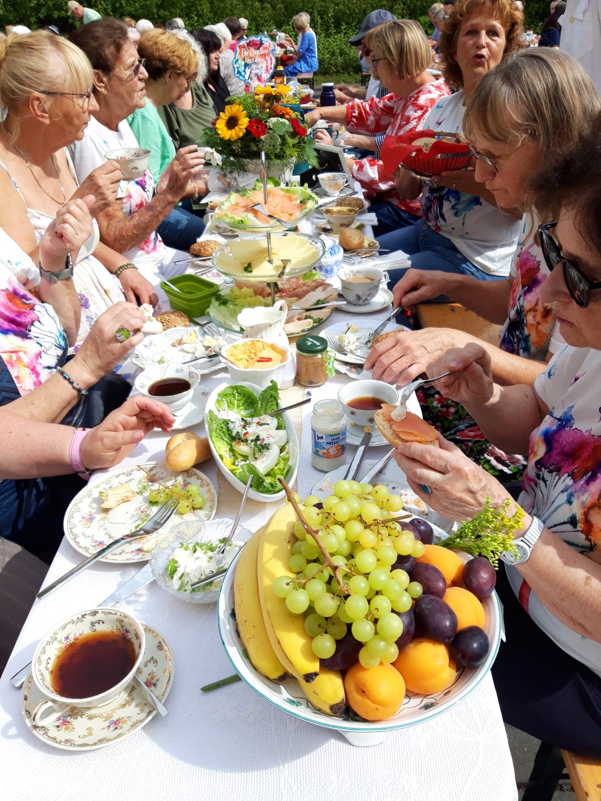 Mehrere Frauen sitzen an einem prall gefüllten Tisch und essen