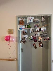 Fotos an Tür und Luftballons am Namensschild von Pflegedienstleitung