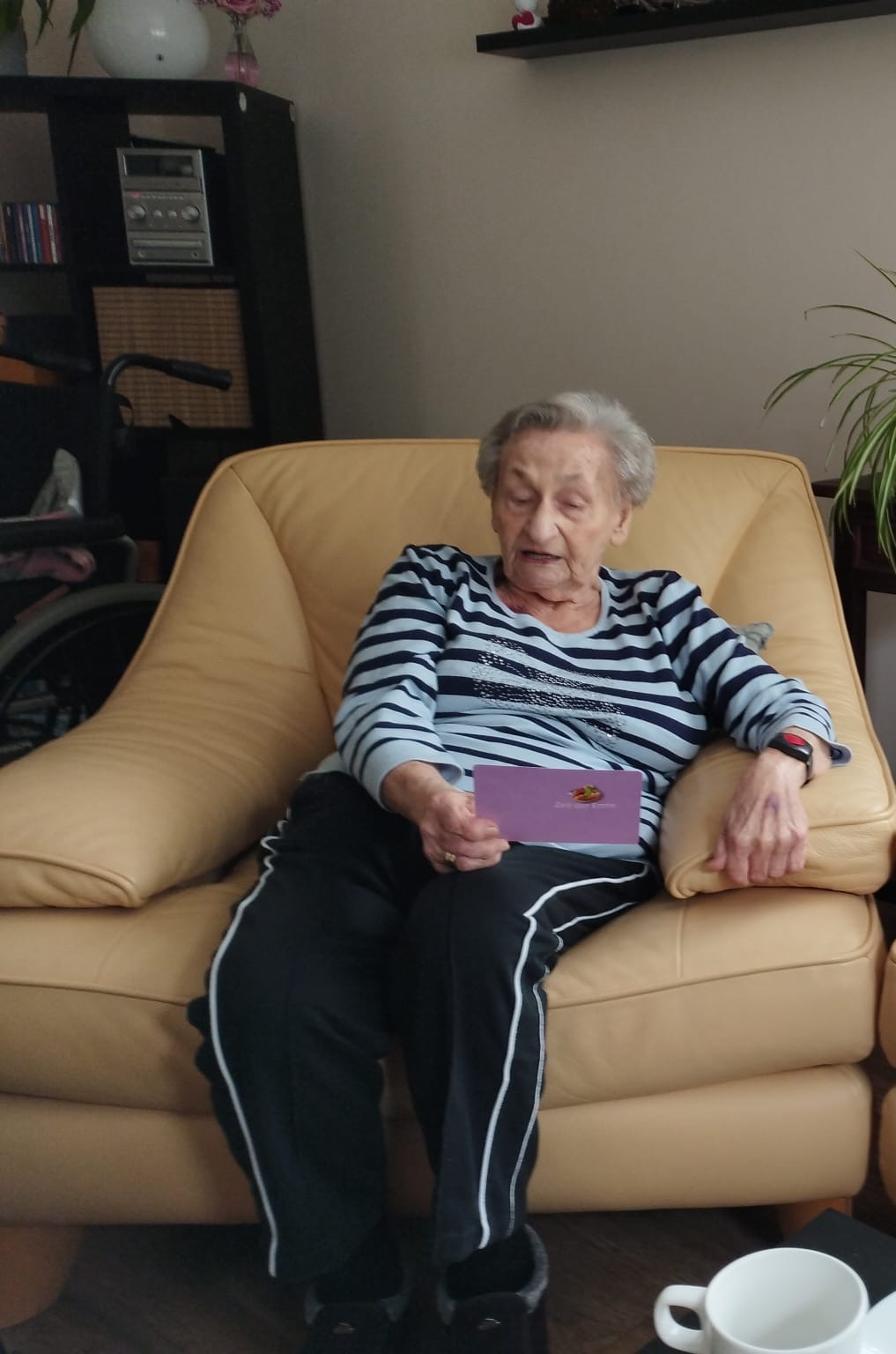 Frau sitzt auf Sessel und hält eine Karte in der Hand