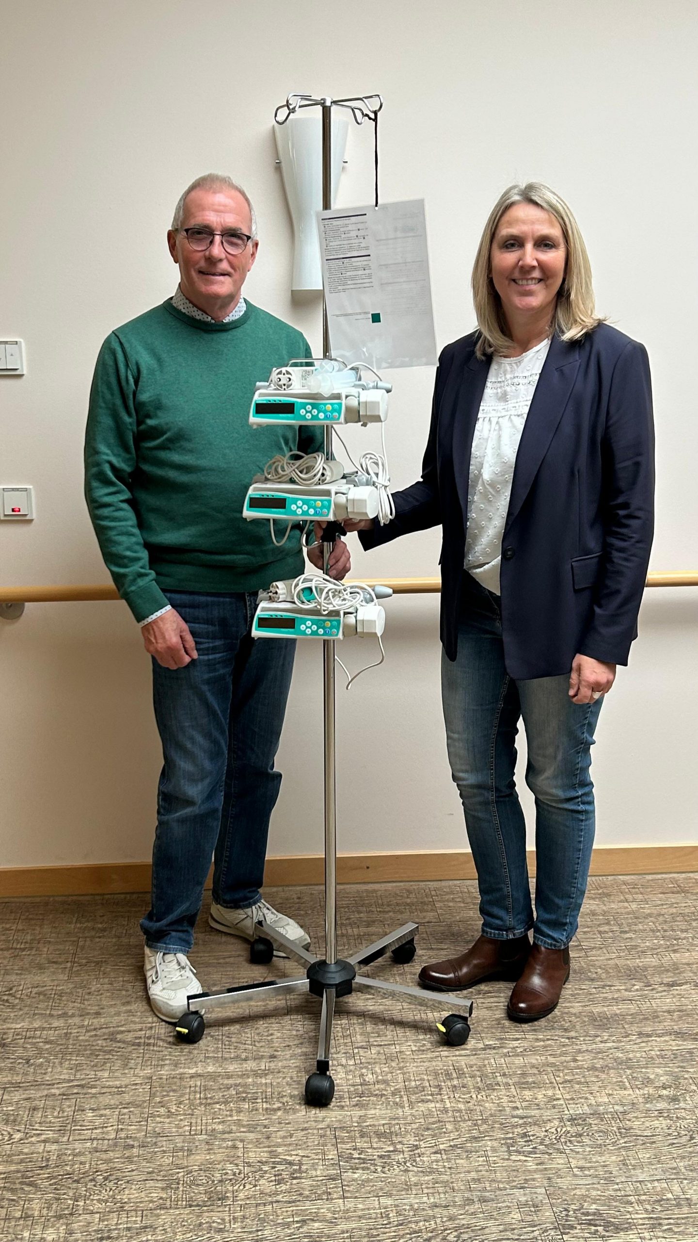 Geschäftsführerin und Spender stehen vor Perfusor im Hospizeingang