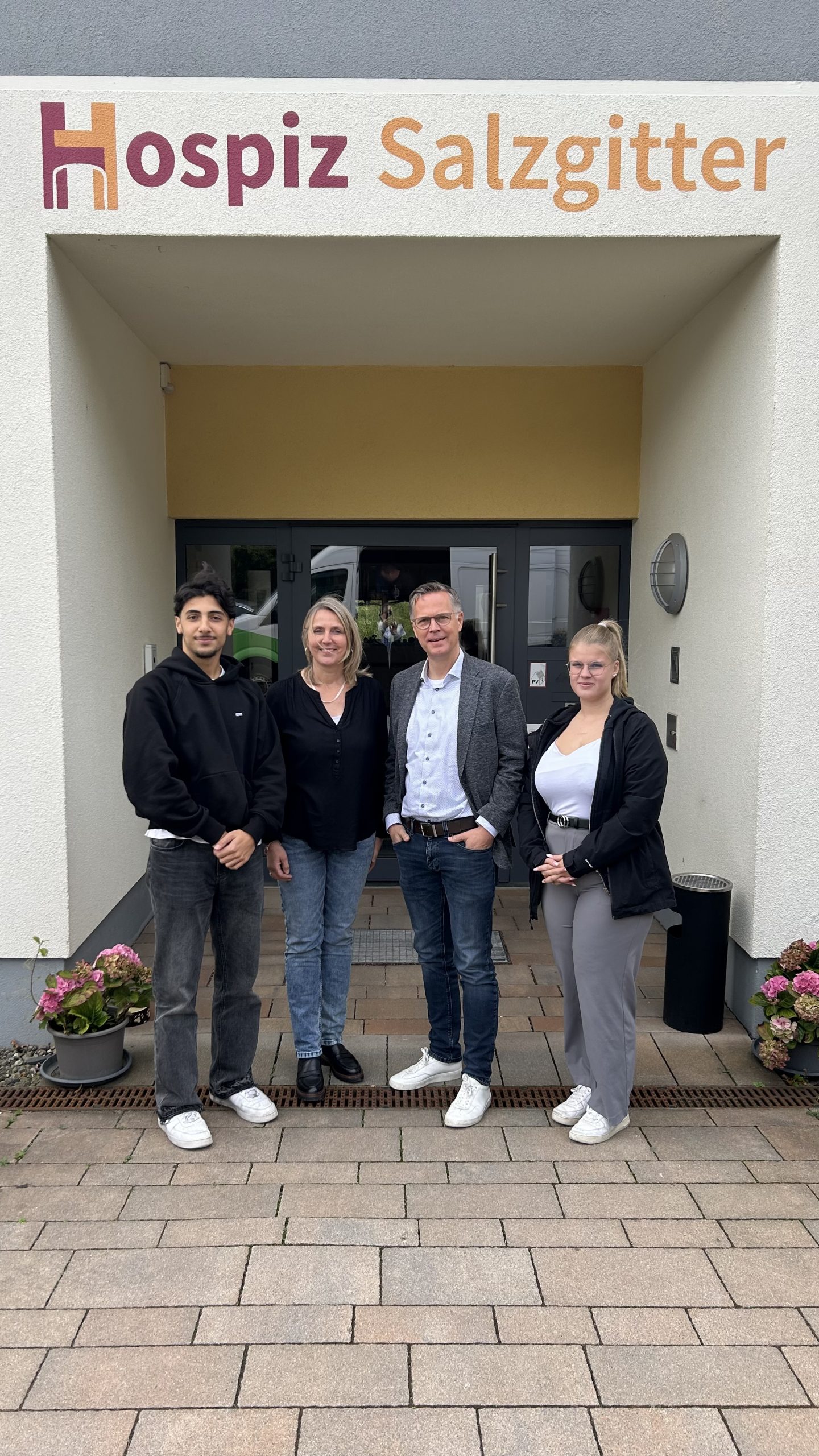 Geschäftsführerin vom Hospiz, Integrationsexperte von VW Salzgitter sowie 2 Auszubildende von VW Salzgitter stehen vor Hospizeingang
