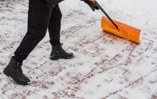 Mensch mit Schneeschieber im Schnee