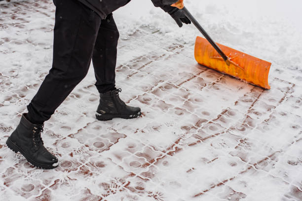 Mensch mit Schneeschieber im Schnee