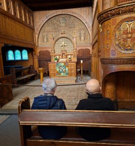Gast und Frau sitzen in einer Kirche