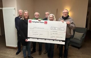 2 Frauen und 4 Männer stehen hinter einem großen symbolischen Scheck