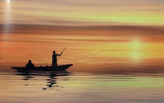 Mann in einem Boot beim Sonnenuntergang