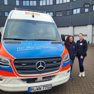 2 Frauen stehen neben dem Wünschewagen