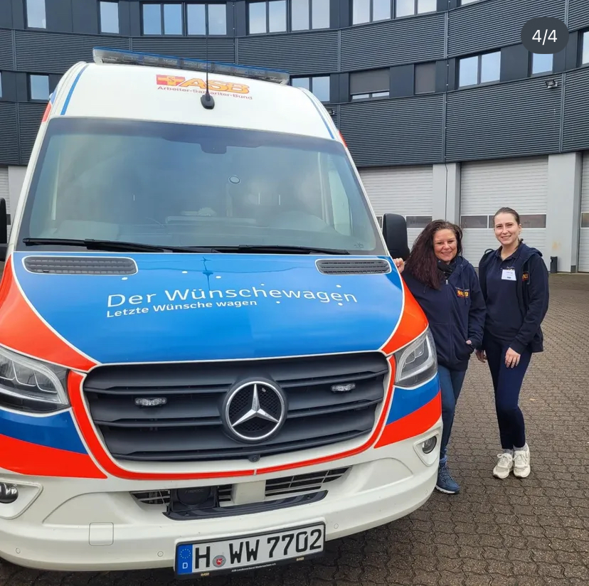 2 Frauen stehen neben dem Wünschewagen