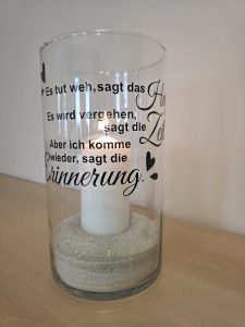 Windlicht Schriftzug und angezündeter Kerze