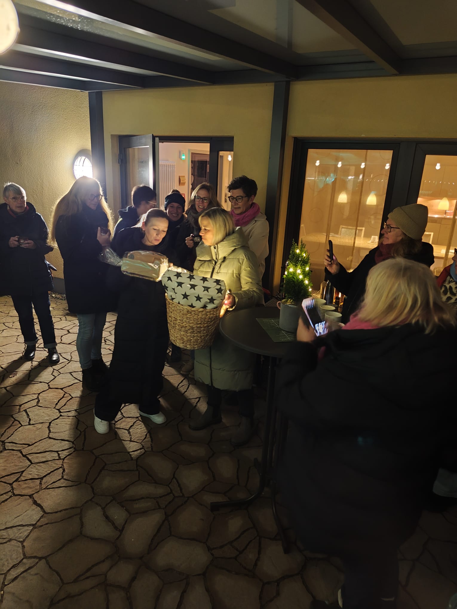 Eine Frau steht mit Geschenken auf der Terrasse Eine Frau steht mit Geschenken auf der Terrasse