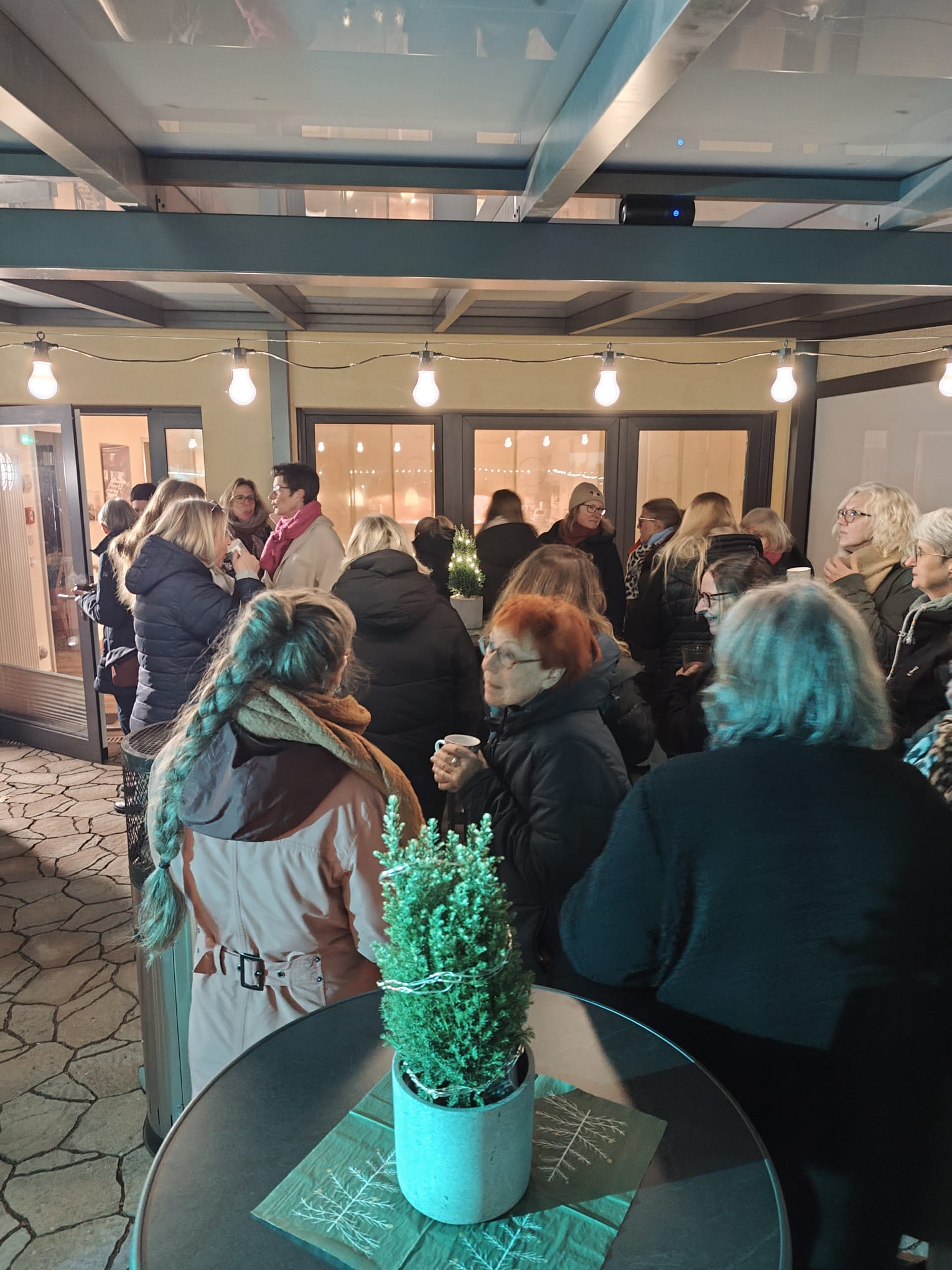 Mehrere Menschen stehen gesellig auf einer Terrasse Mehrere Menschen stehen gesellig auf einer Terrasse