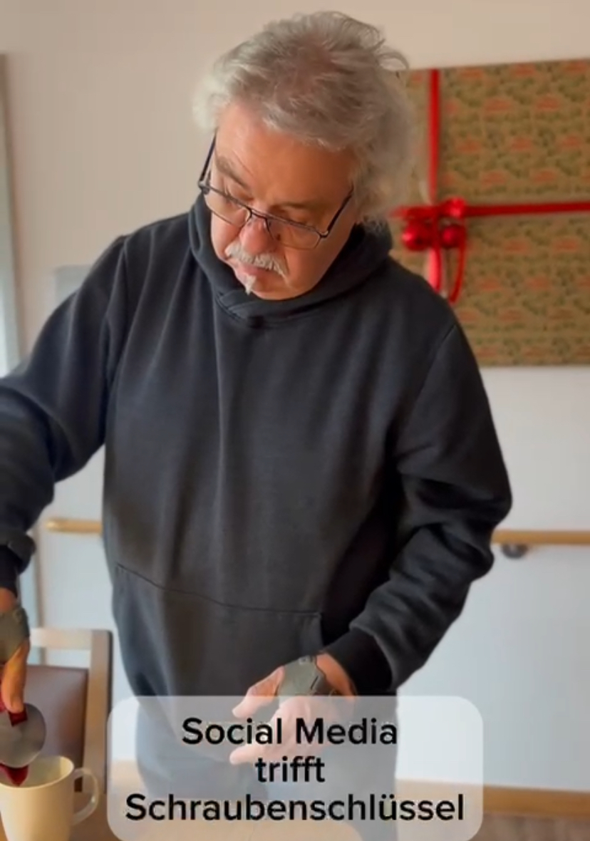 Mann steht am Tisch und schenkt sich Kaffee in eine Tasse ein