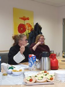 Zwei Frauen sitzen am Tisch und essen