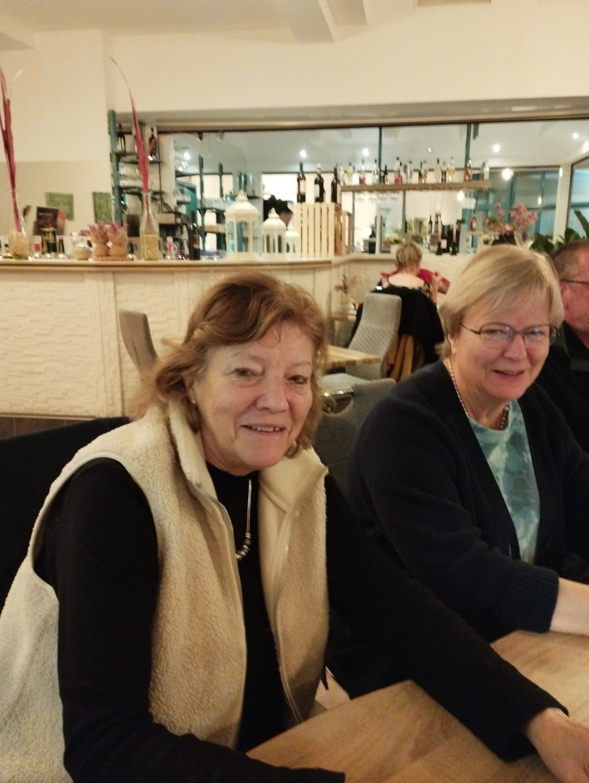 Zwei Frauen sitzen am Tisch und lächeln in die Kamera Zwei Frauen sitzen am Tisch und lächeln in die Kamera