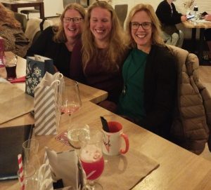 Drei Frauen sitzen lachend am Tisch