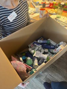 Eine Frau hält einen Karton mit Hygieneartikel in den Händen