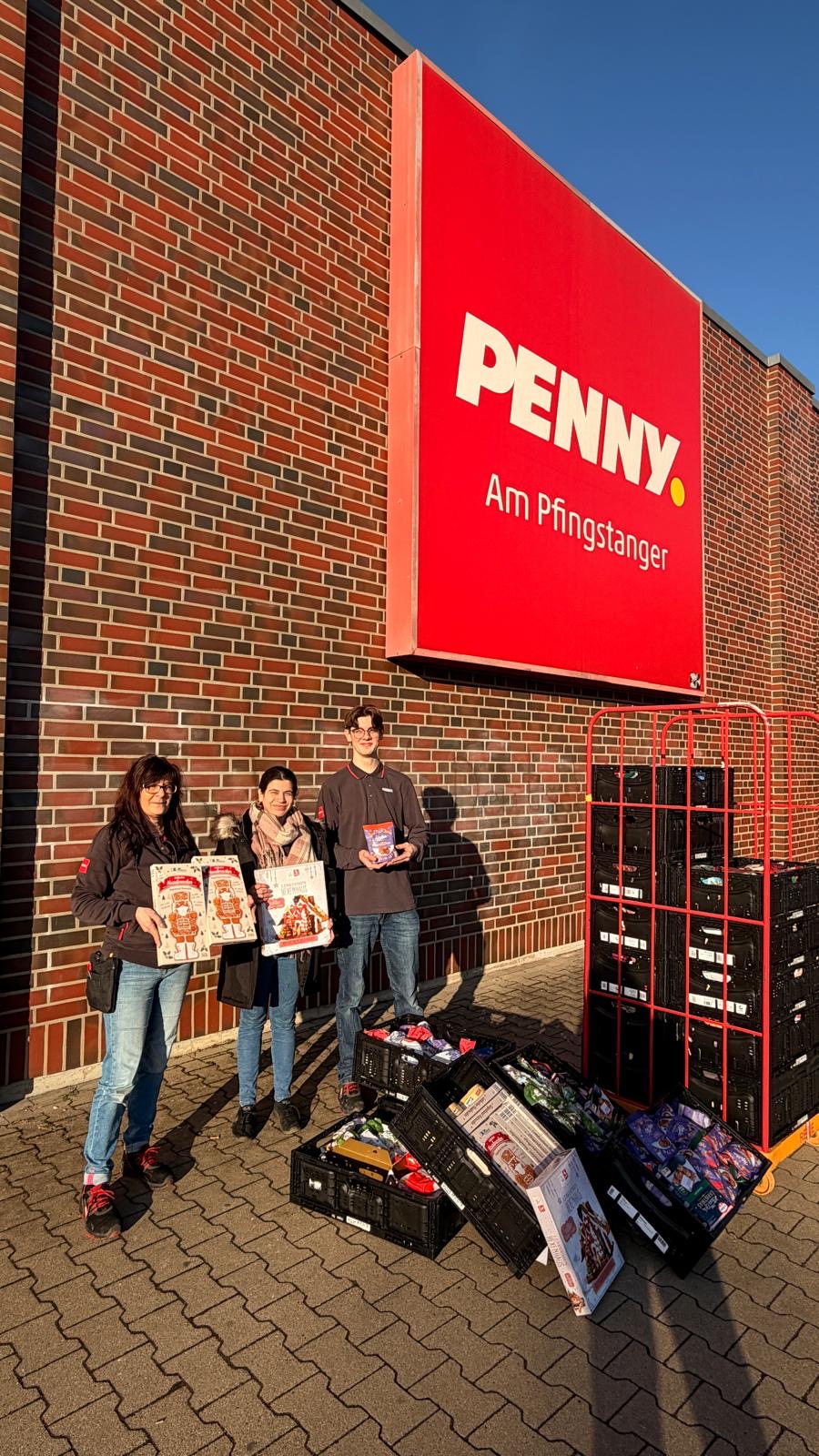 2 Frauen und ein junger Mann stehen vor einem Supermarkt und halten Lebkuchenhäuser in den Händen 2 Frauen und ein junger Mann stehen vor einem Supermarkt und halten Lebkuchenhäuser in den Händen