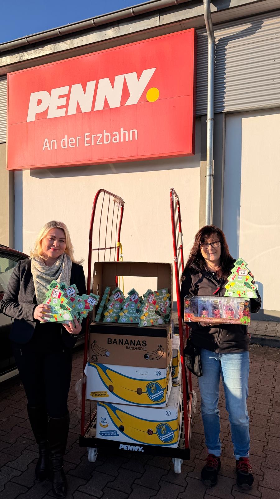 2 Frauen stehen vor einem Wagen. Auf dem Wagen liegen Süßigkeiten 2 Frauen stehen vor einem Wagen. Auf dem Wagen liegen Süßigkeiten