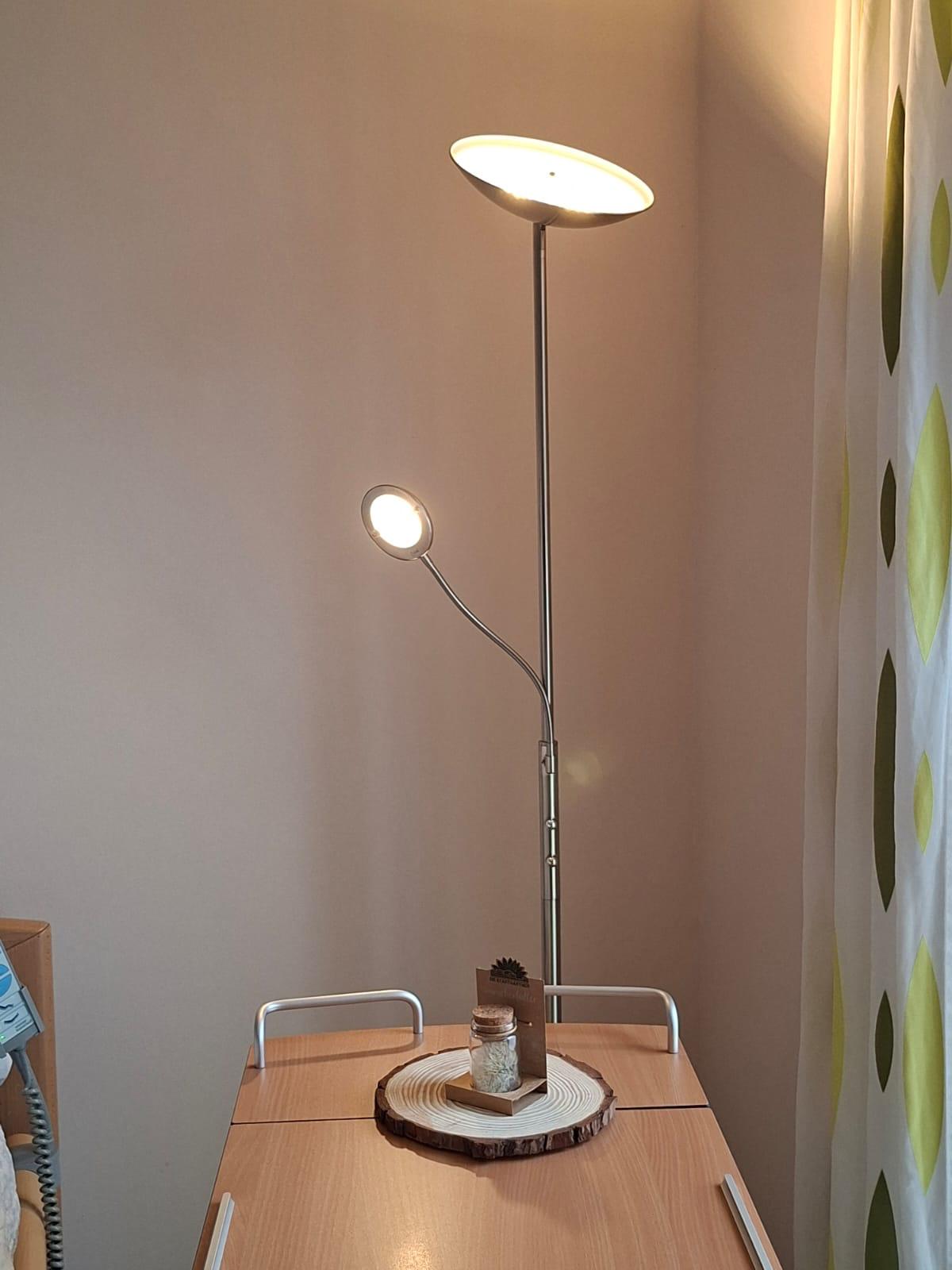 Eine neu gespendete Stehlampe steht hinter einem Tisch Eine neu gespendete Stehlampe steht hinter einem Tisch