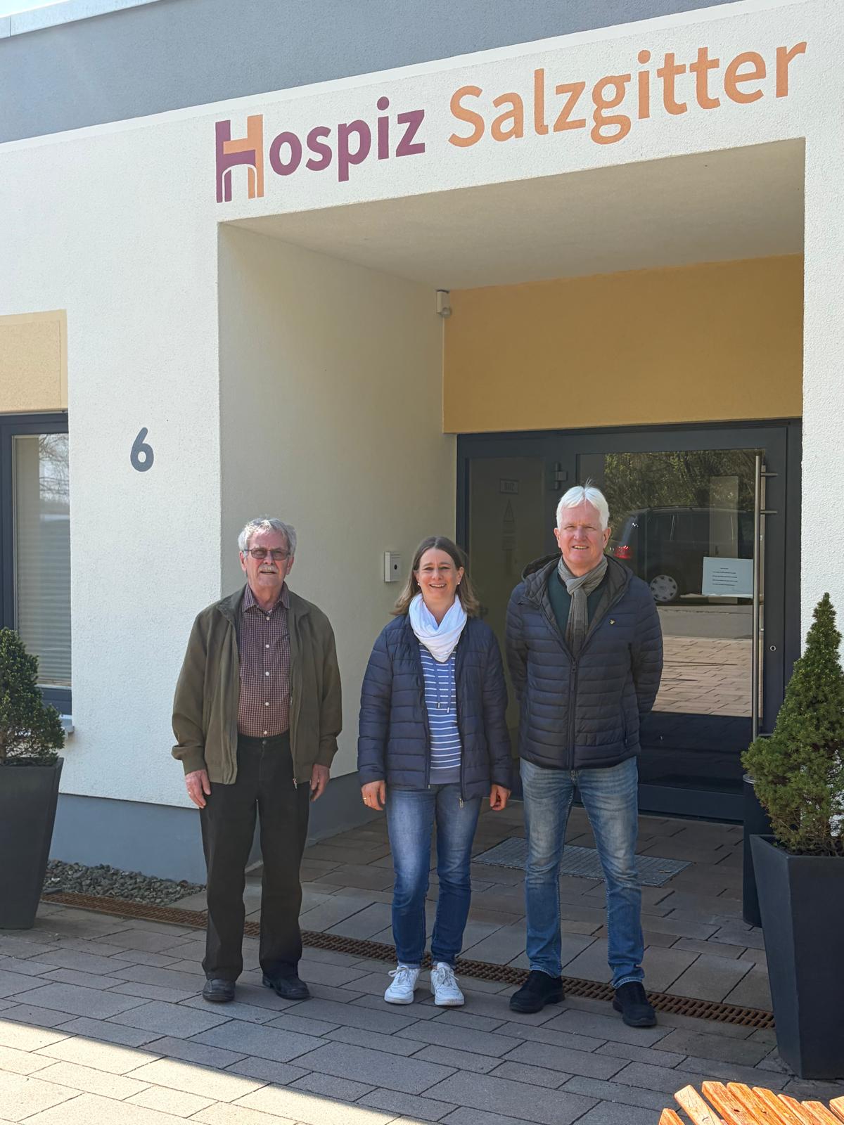 Oberstleutnant a. D. Uwe Fenger, Kamerad Rüdiger Fregin und Mitarbeiterin vom Hospiz Jasmin Libich stehen vor dem Hospizeingang