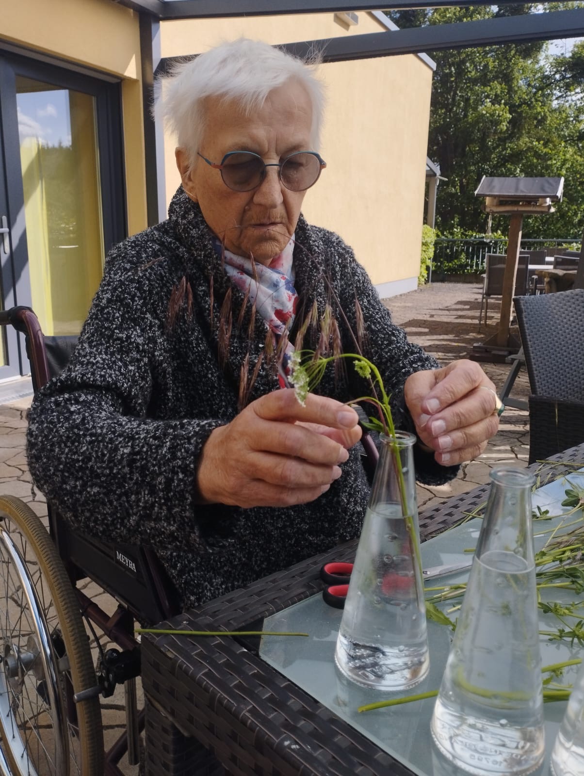 Gast stellt Blumen in eine Vase Gast stellt Blumen in eine Vase