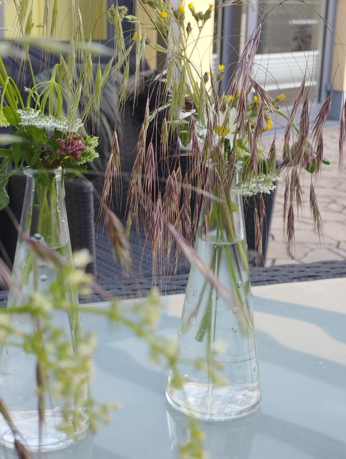 Zwei Vasen mit selbst gepflückten Blumen stehen auf dem Tisch Zwei Vasen mit selbst gepflückten Blumen stehen auf dem Tisch