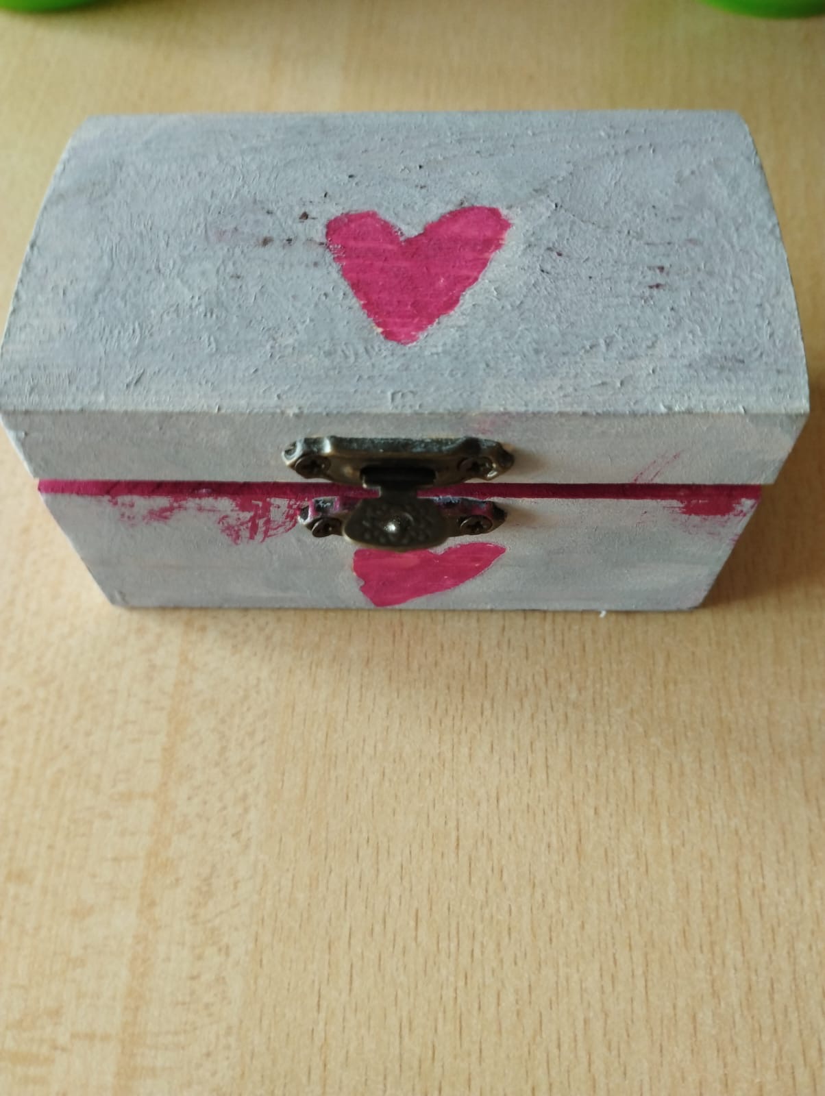 Graues Kästchen mit pinkfarbenem Herz steht auf dem Tisch