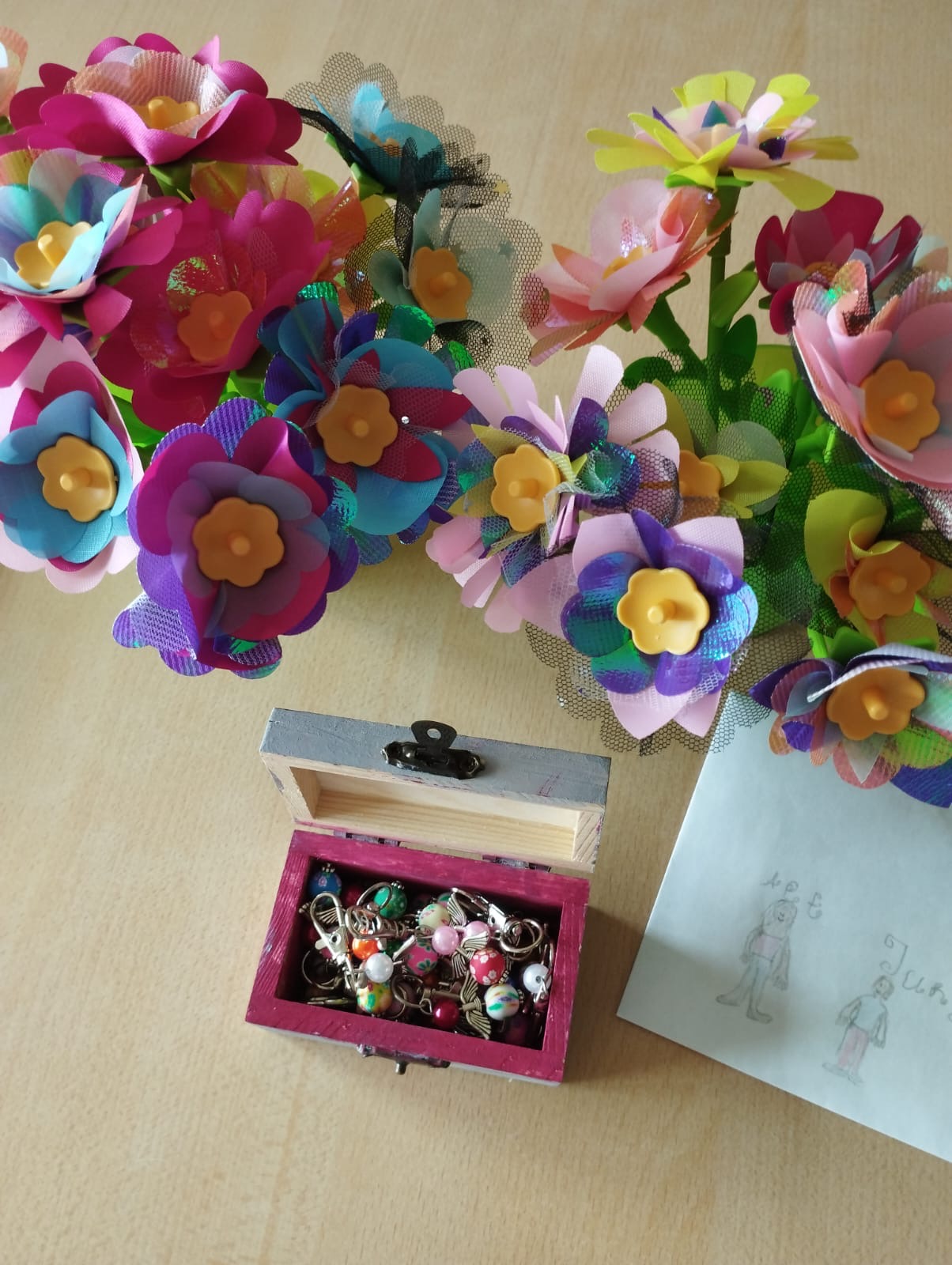 2 Sträuße gebastelte Blumen und Kästchen mit Schutzengel stehen auf dem Tisch