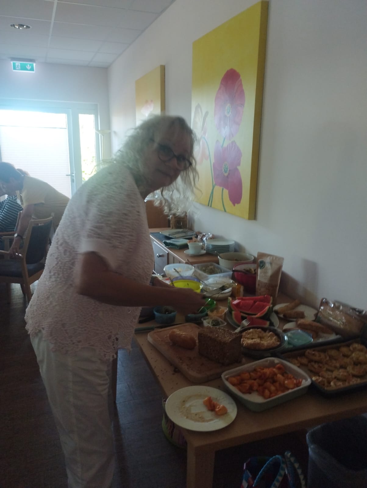Ehrenamtliche Mitarbeiterin Maren Loewe steht am Buffet Ehrenamtliche Mitarbeiterin Maren Loewe steht am Buffet